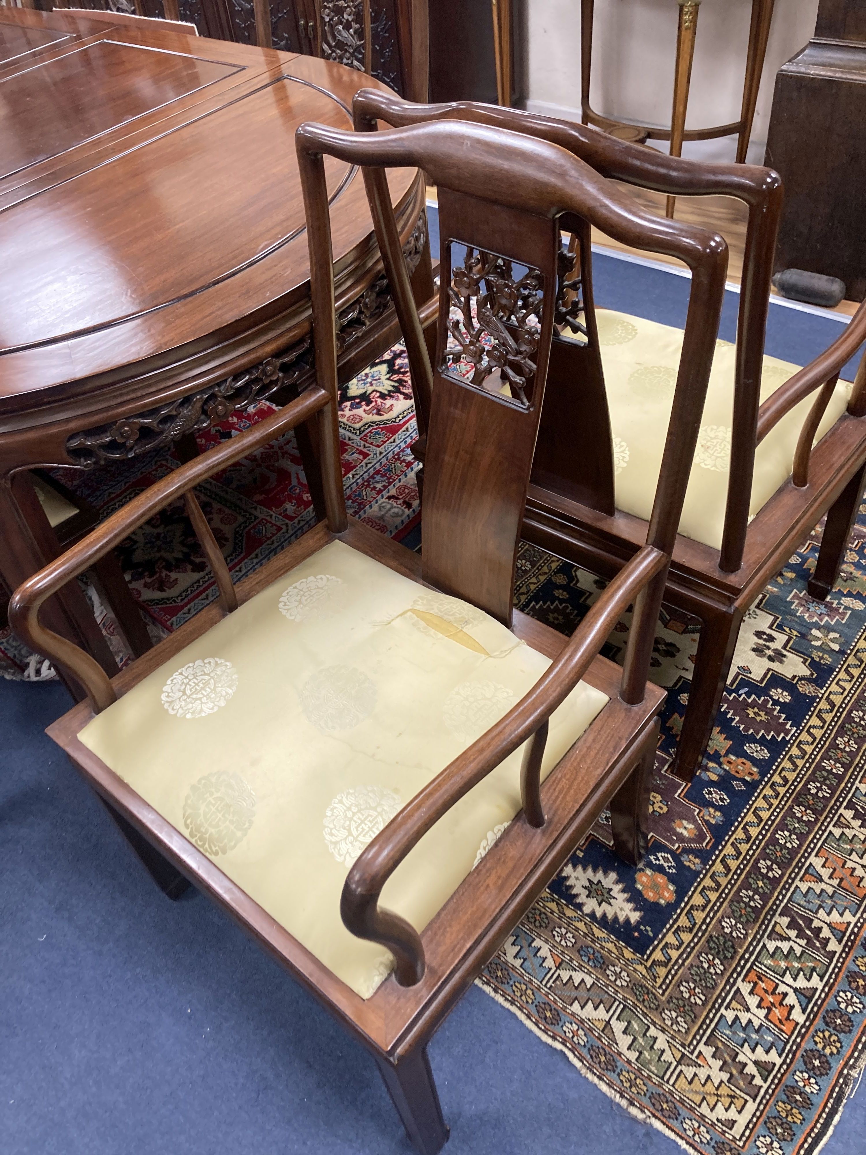 A 20th century Chinese carved hardwood dining room suite comprising sideboard fitted with four drawers above four carved panelled cupbo